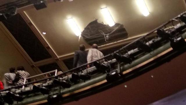 People look at the collapsed roof of Piccadilly Theatre during 'Death of a Salesman' play in London