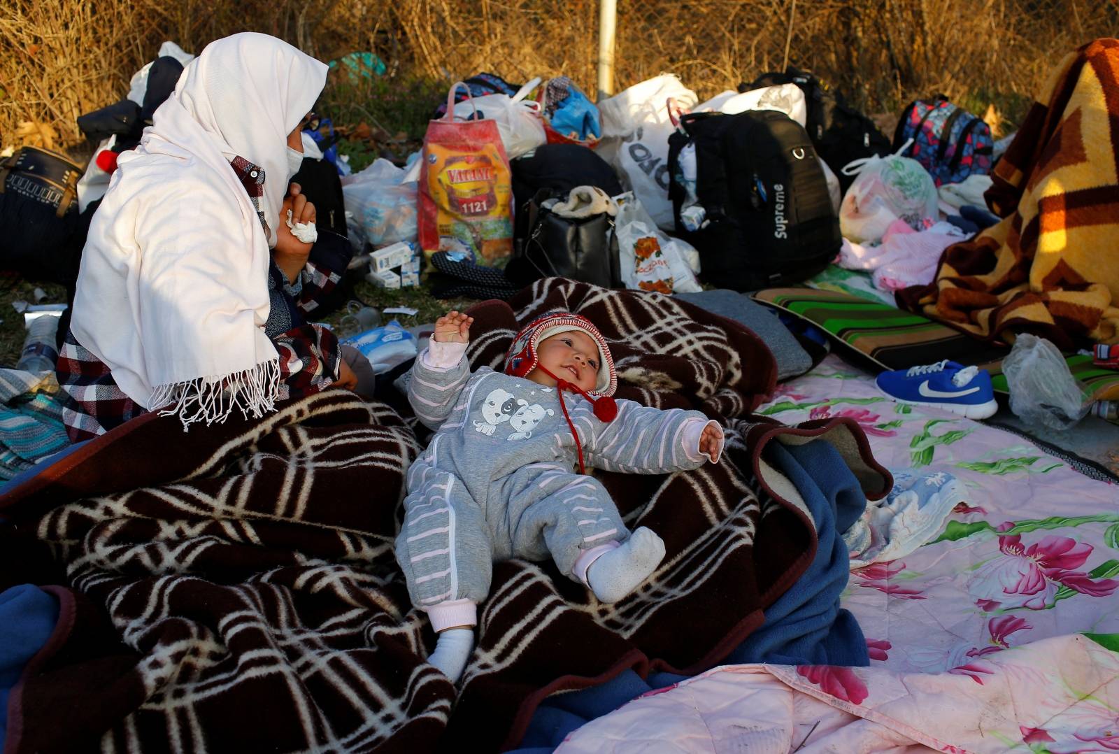 A migrant child lies on a blanket near Turkey's Pazarkule border crossing with Greece's Kastanies, near Edirne