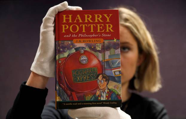 FILE PHOTO: One of the first ever copies of "Harry Potter and the Philosopher's Stone" by J.K. Rowling, is held by a staff member at Bonhams auctioneers, ahead the Fine Books, Manuscripts, Atlases and Historical Photographs sale in London
