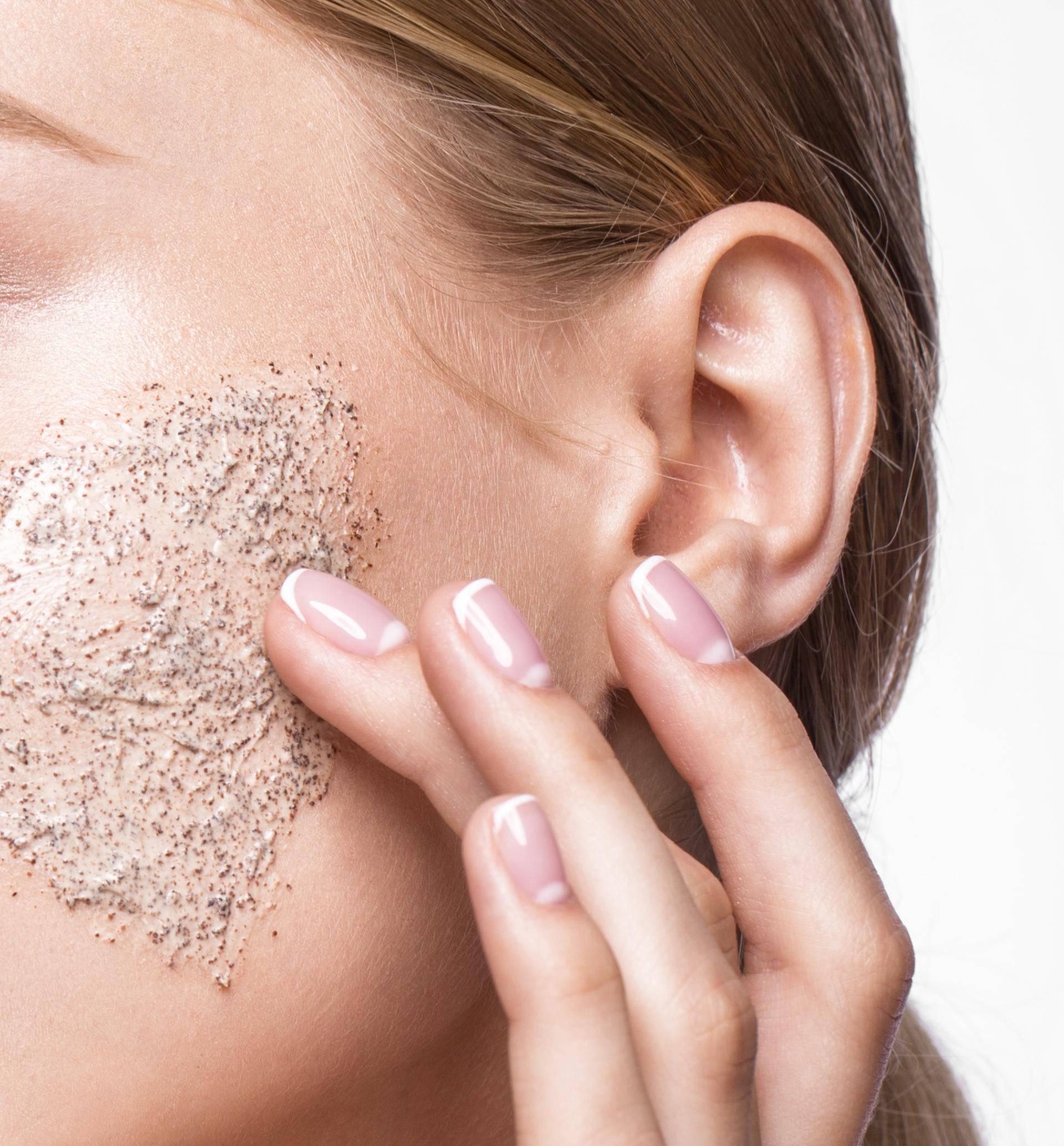 Beautiful young girl with scrub on the skin, French manicure