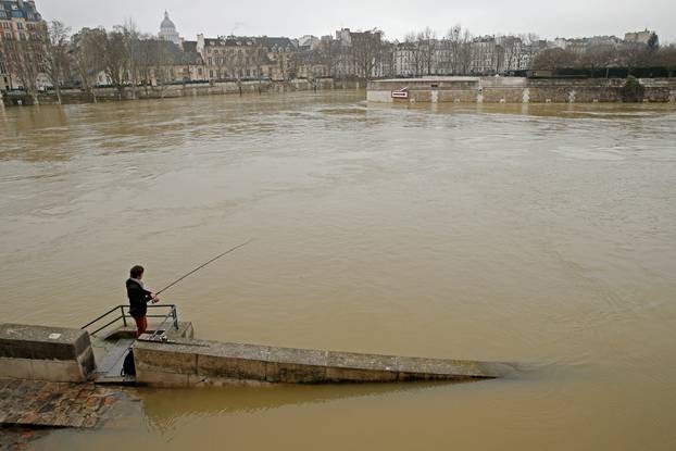 A man fishes on the flooded banks of the River Seine in Paris
