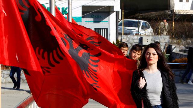 A girl passes next to Albanian flags ahead of tomorrow's 10 year independence celebration in Kacanik