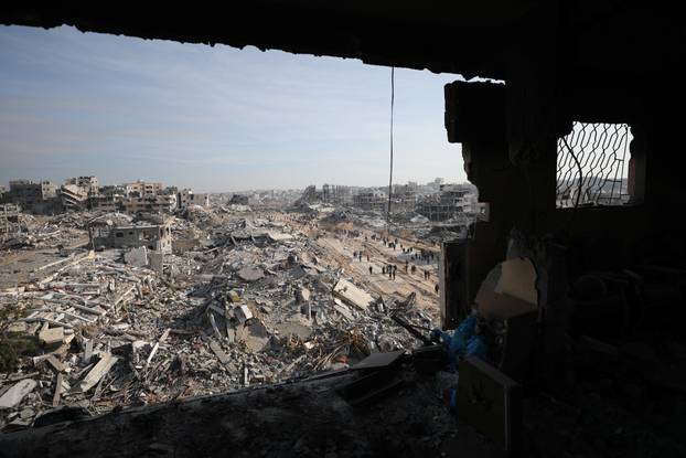 Displaced Palestinians walk past the rubble as they attempt to return to their homes, in the northern Gaza Strip