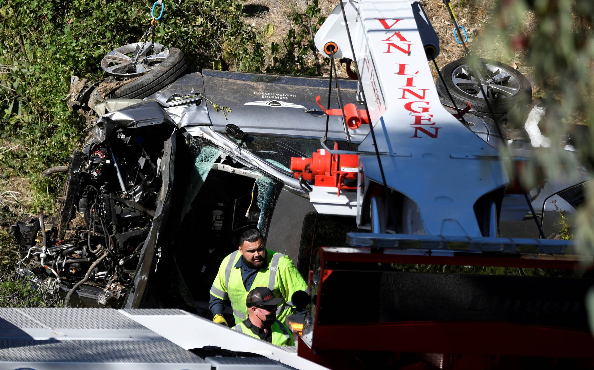 The vehicle of golfer Tiger Woods is lifted by a crane in Los Angeles