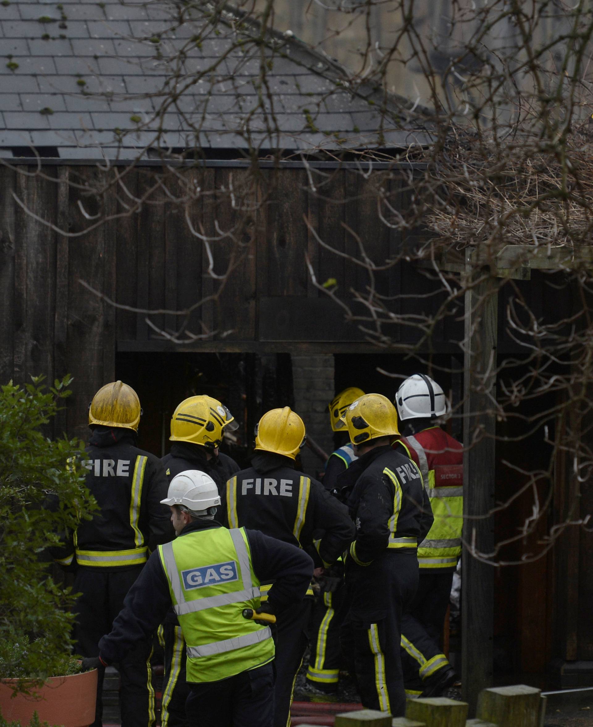 Firefighters stand in the grounds of London Zoo following a fire which broke out at a shop and cafe at the attraction, in central London