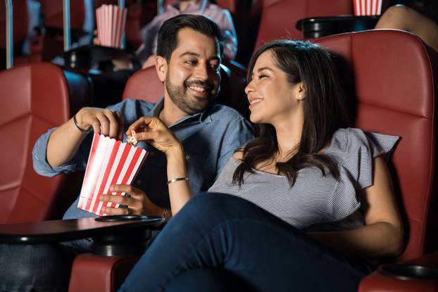 Couple sharing popcorn at the movies