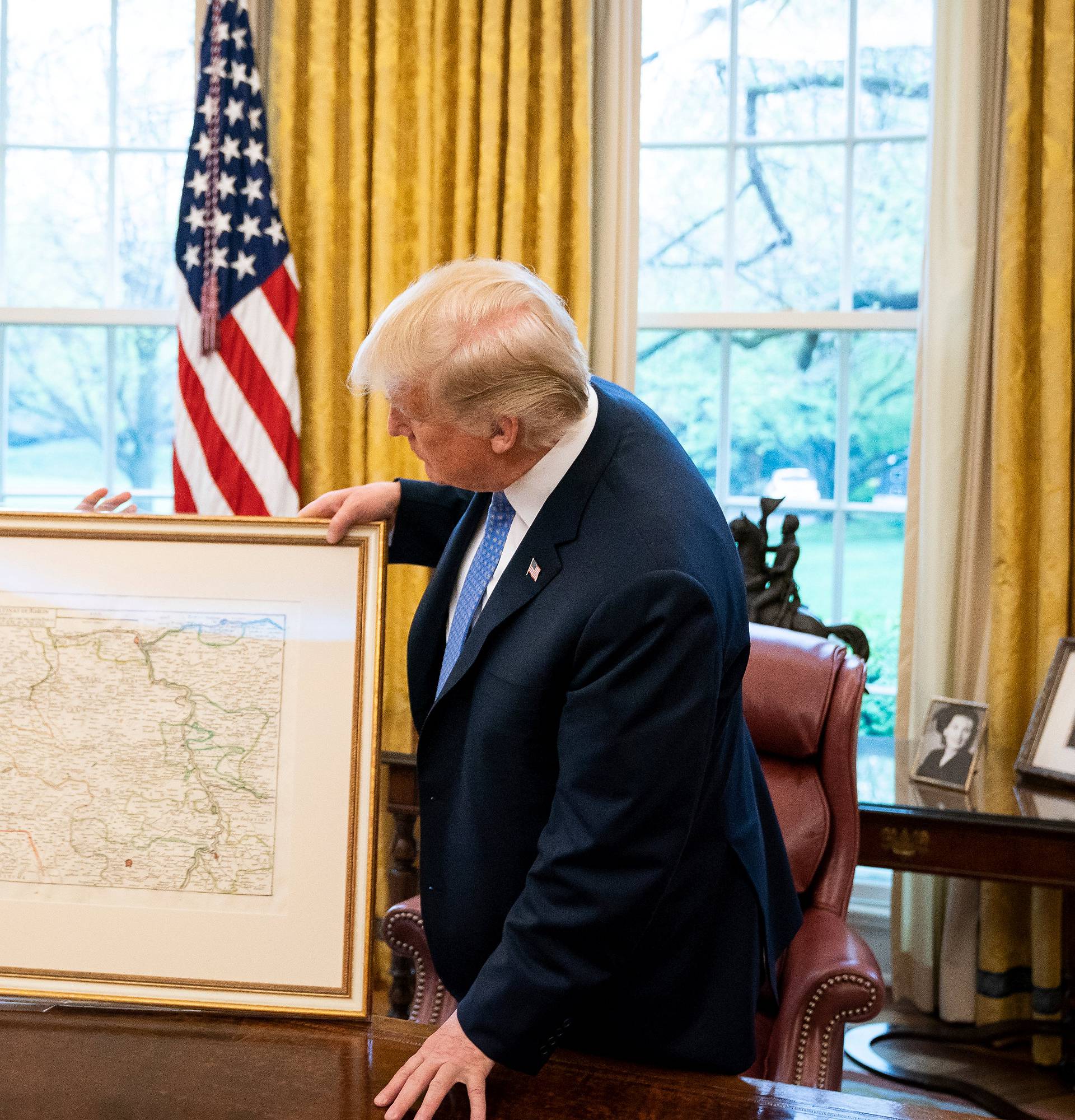 U.S. President Donald Trump receives from German Chancellor Angela Merkel a historical map of the Germany's region Rhenish Palatinate from 1705 at the White House in Washington