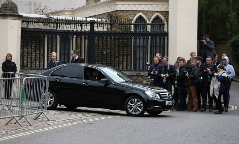 A car drives past members of the media outside Highgate Cemetery in London