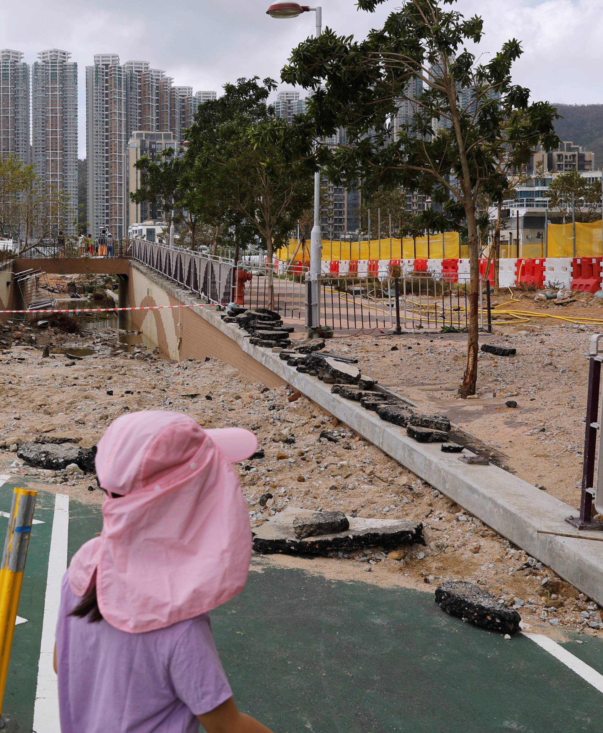 Children walk through a damaged path after Super Typhoon Mangkhut hit Hong Kong
