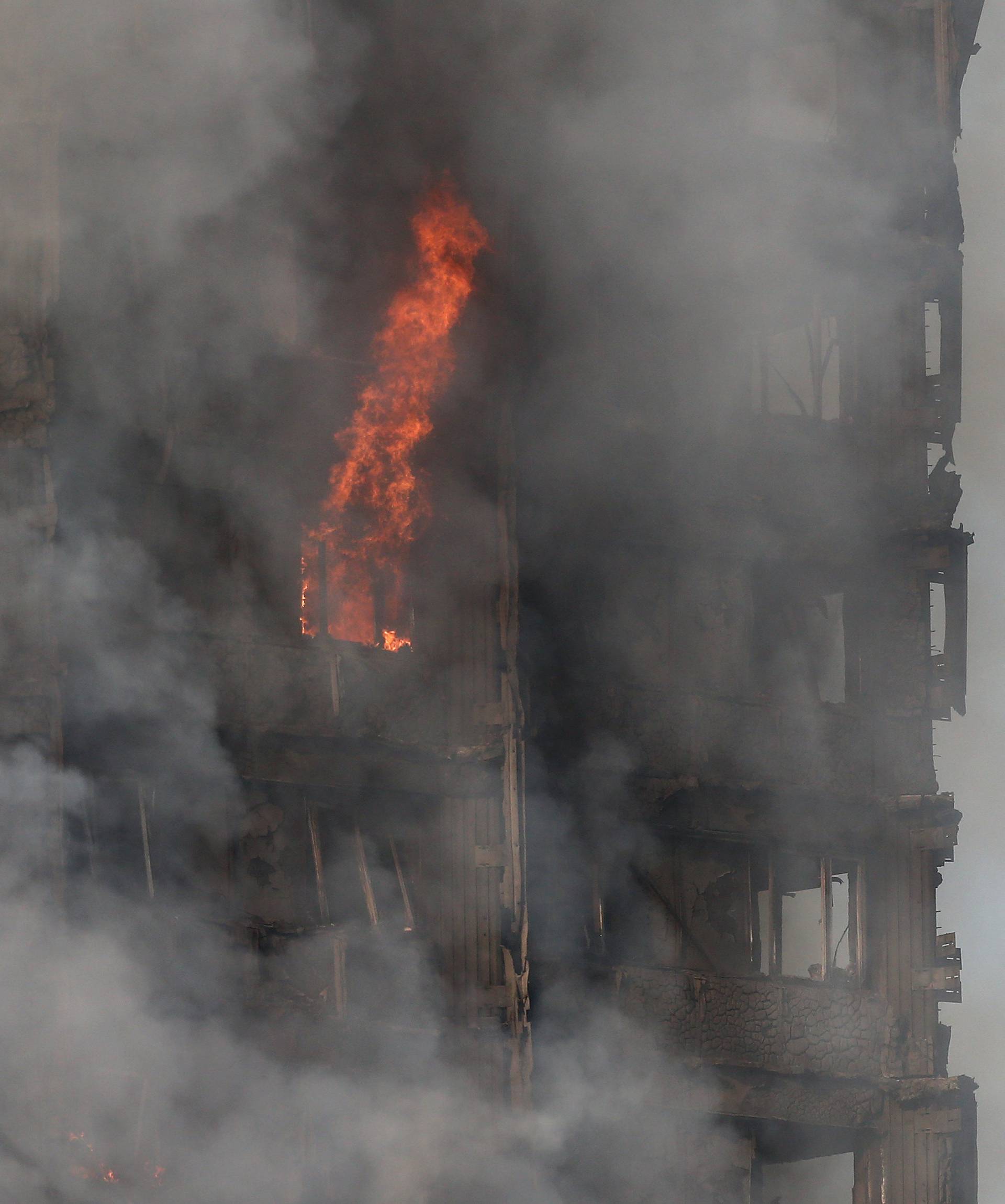 Smoke and flames billow as firefighters deal with a serious fire in a tower block at Latimer Road in West London
