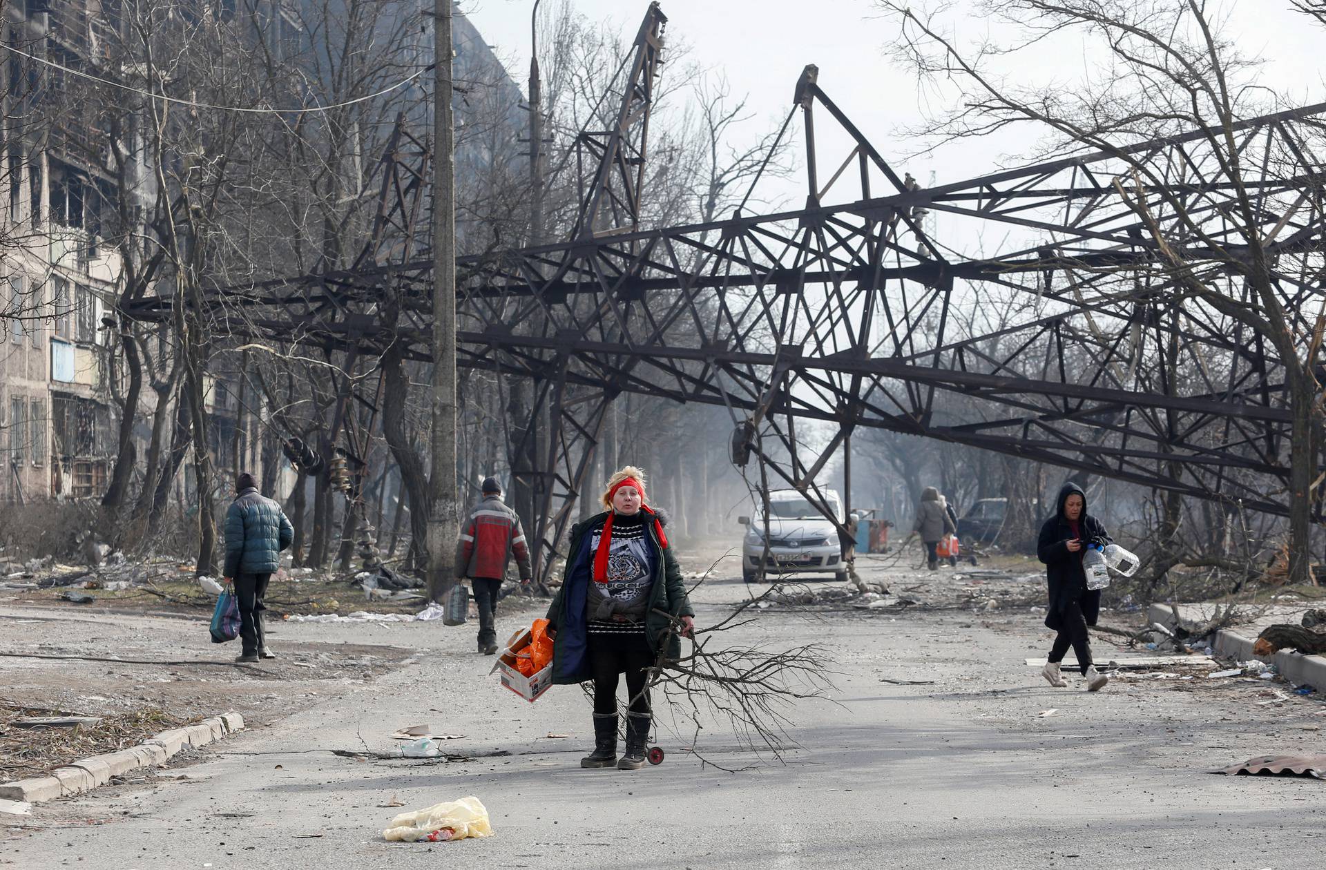 Local residents walk in a street in the besieged city of Mariupol