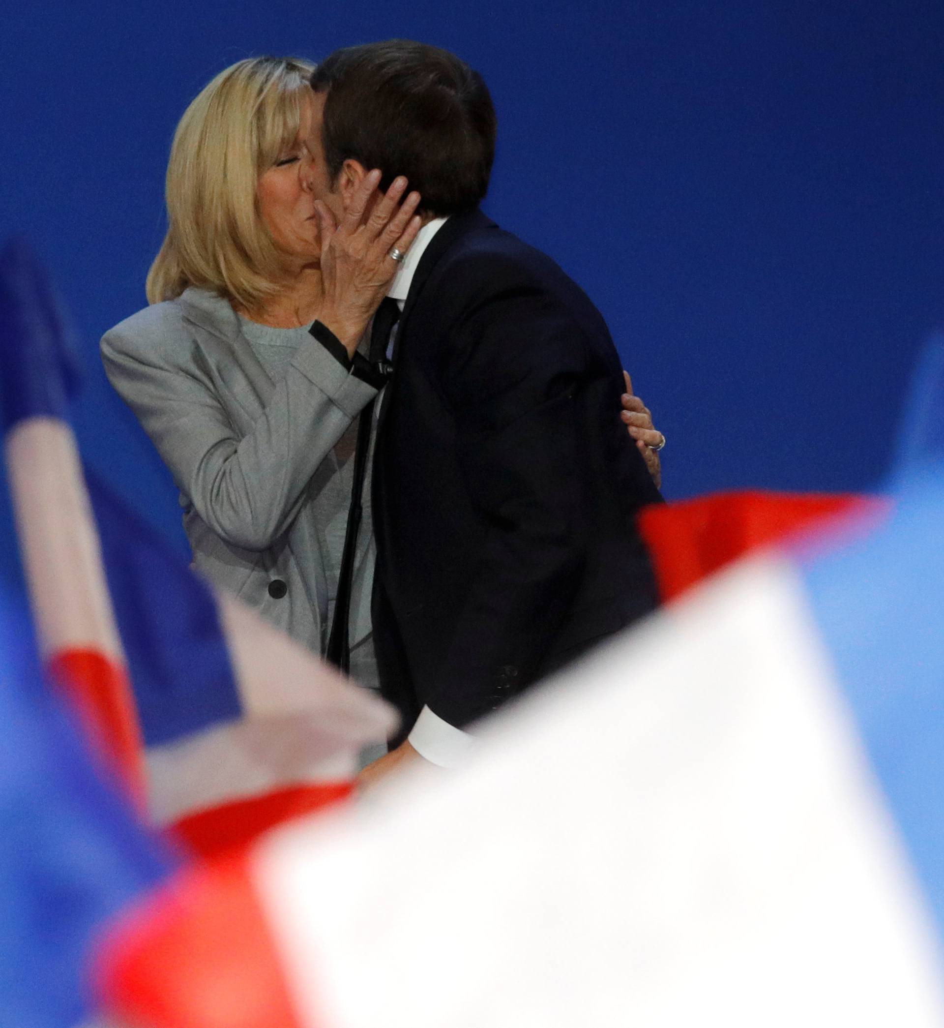 Emmanuel Macron, head of the political movement En Marche !, or Onwards !, and candidate for the 2017 French presidential election, kisses his wife Brigitte Trogneux as he arrives on stage to deliver a speech at the Parc des Expositions hall in Paris