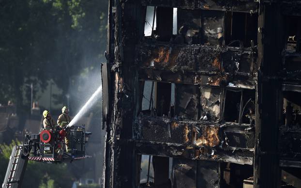 Firefighters spray water onto the Grenfell Tower block which was destroyed in a disastrous fire, in north Kensington, West London