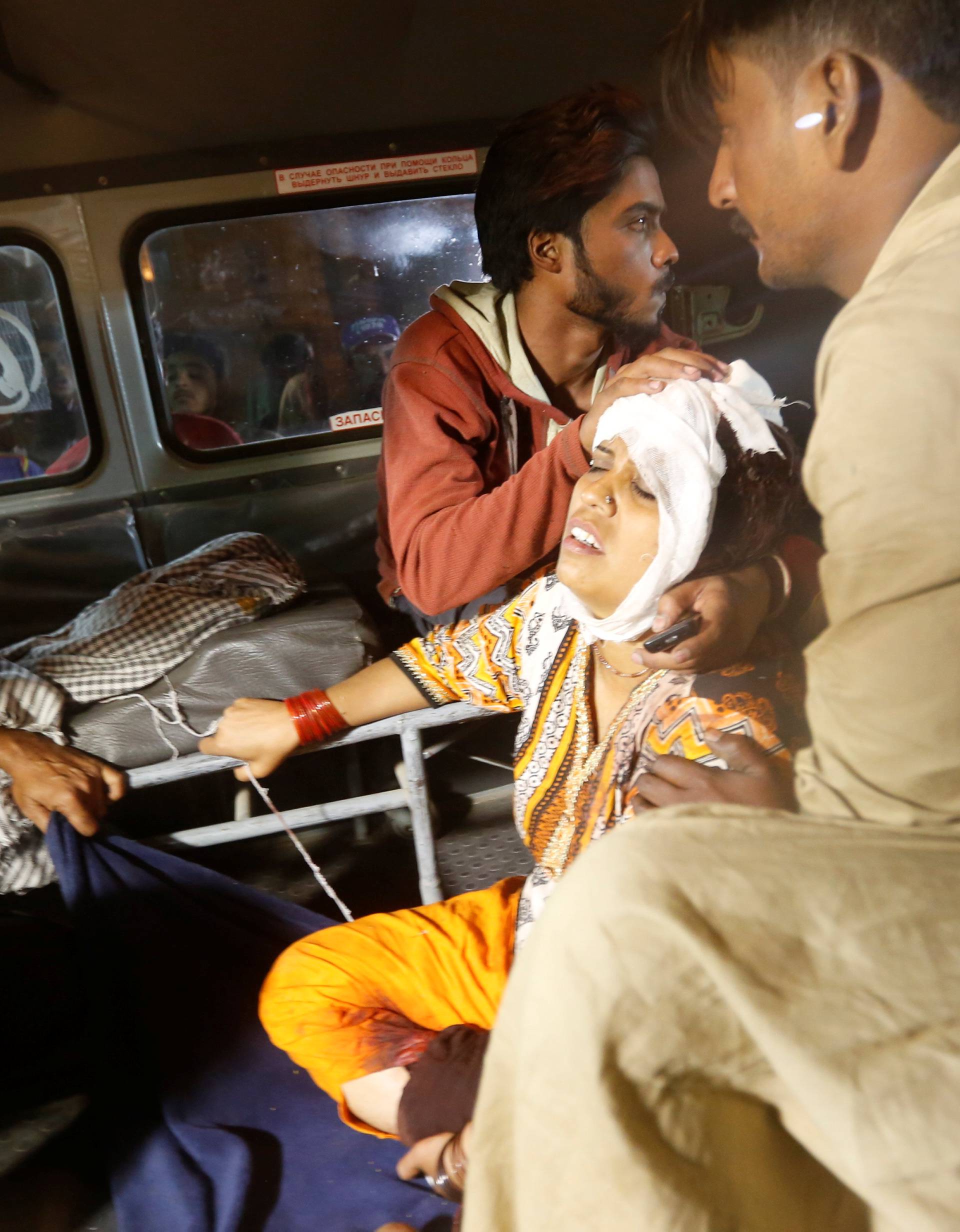 A woman sits in an ambulance as she arrives by ambulance after an explosion in at the Shah Noorani Shrine in Baluchistan, at a hospital in Karachi