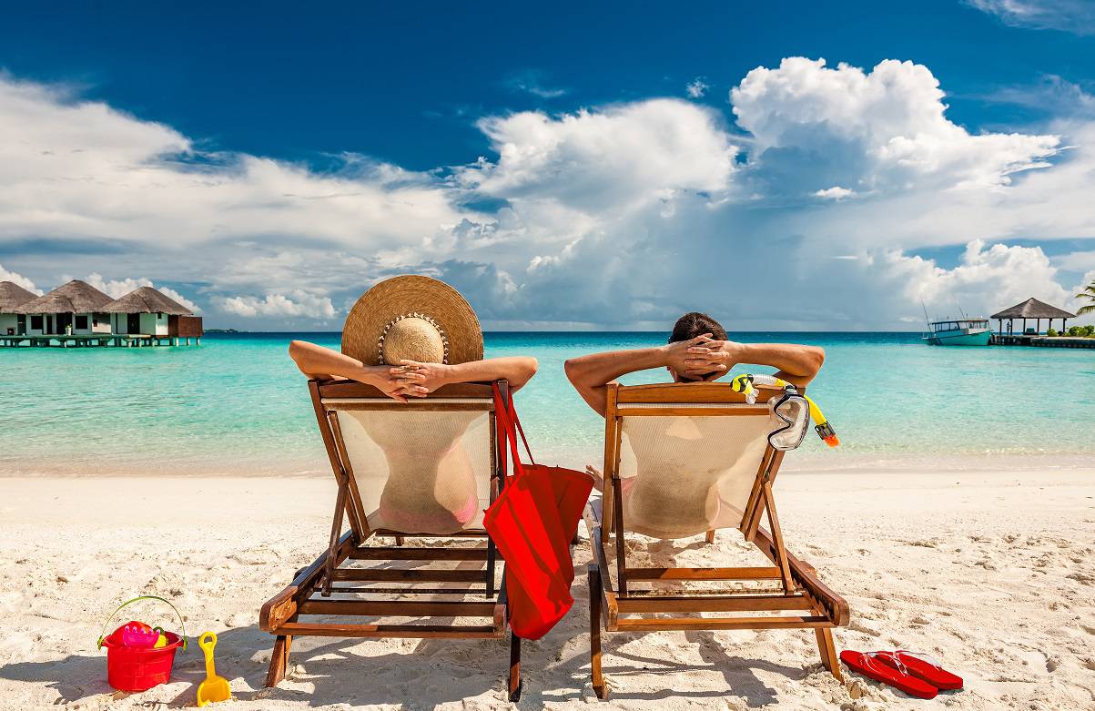 Couple in loungers on beach at Maldives