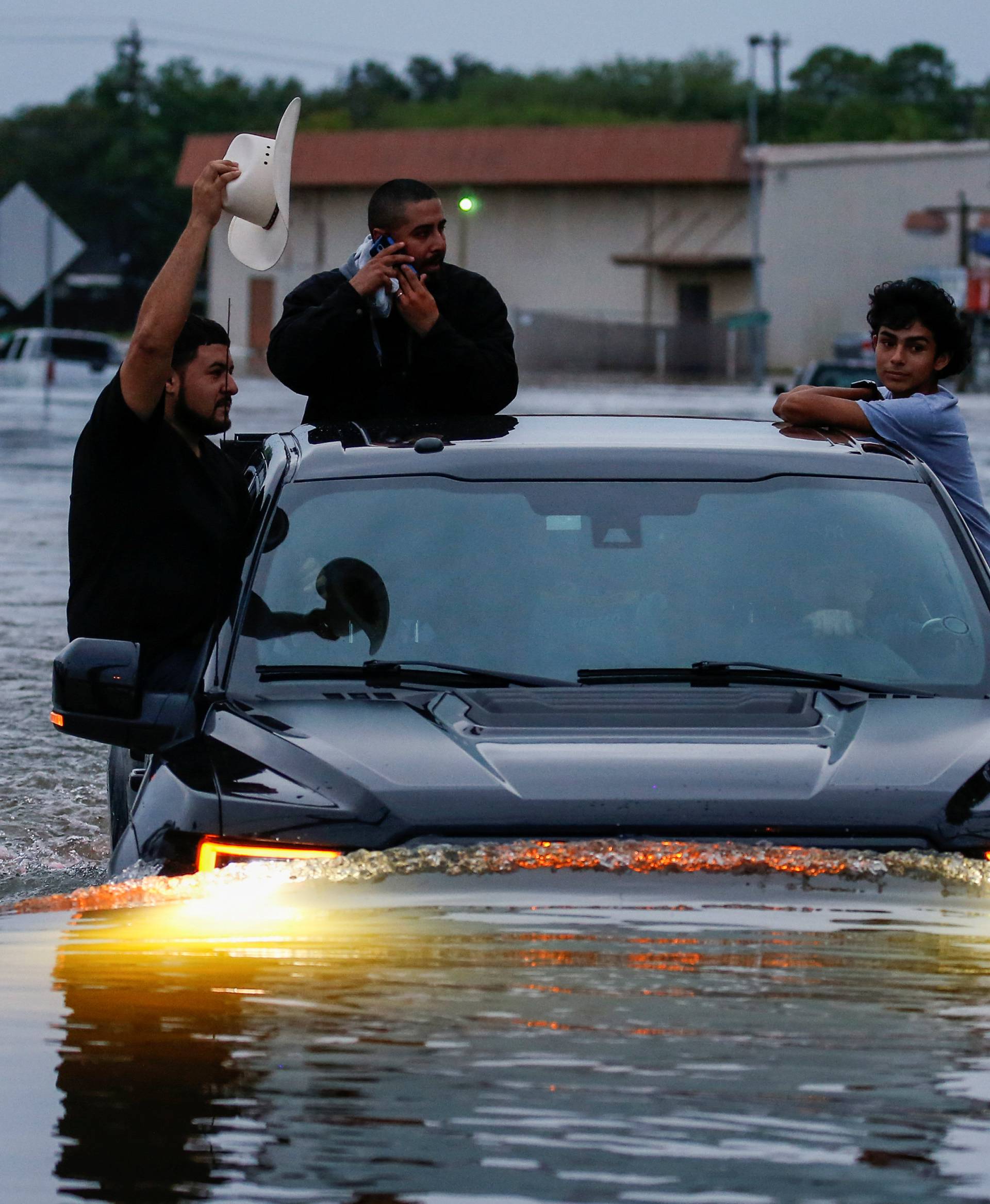 Residents use a truck to navigate through flood waters from Tropical Storm Harvey in Houston, Texas,