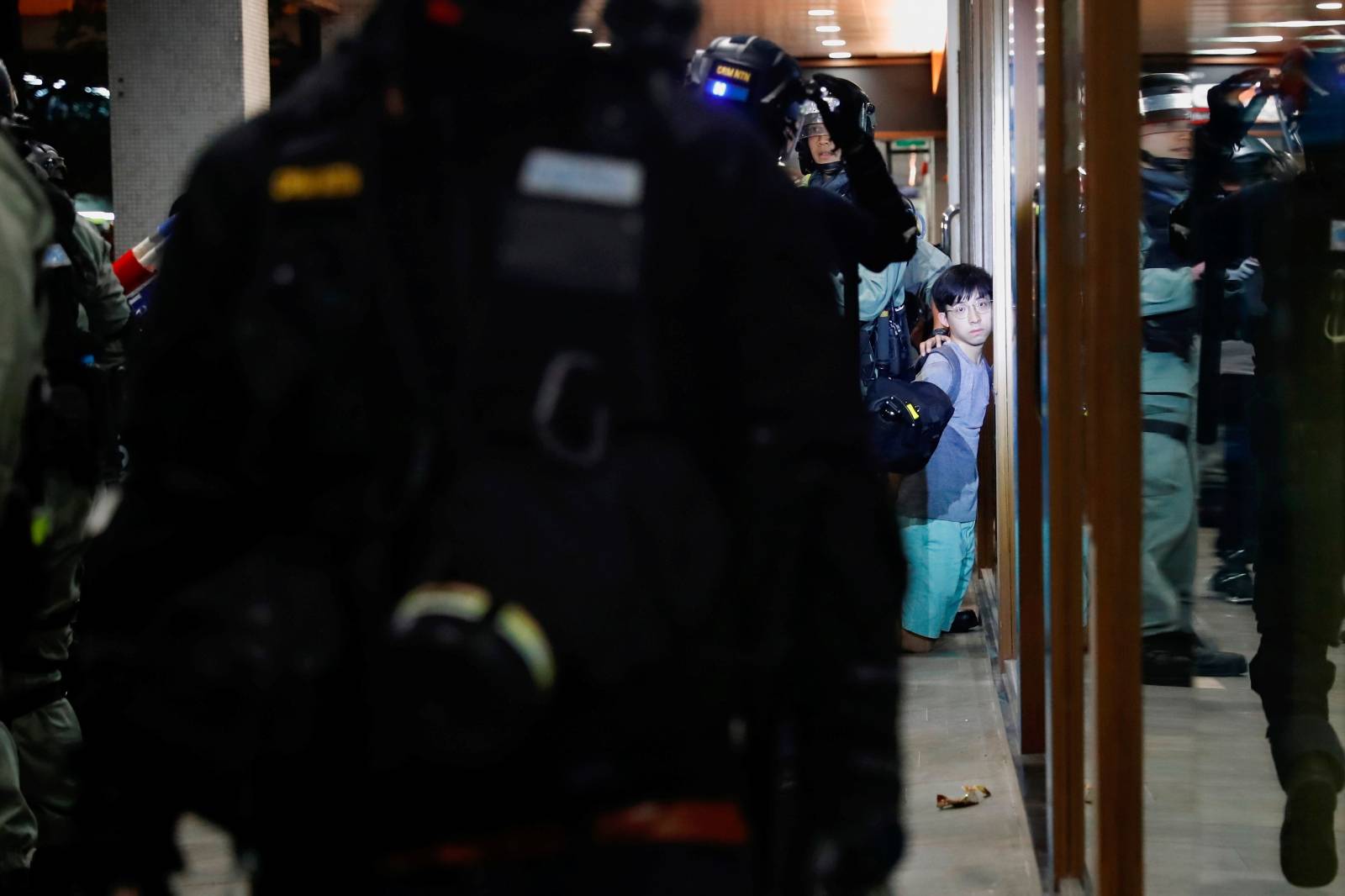 Riot police detain an anti-government protester at shopping mall in Tai Po, Hong Kong