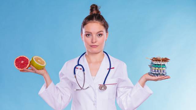 Woman with diet weight loss pills and grapefruits.