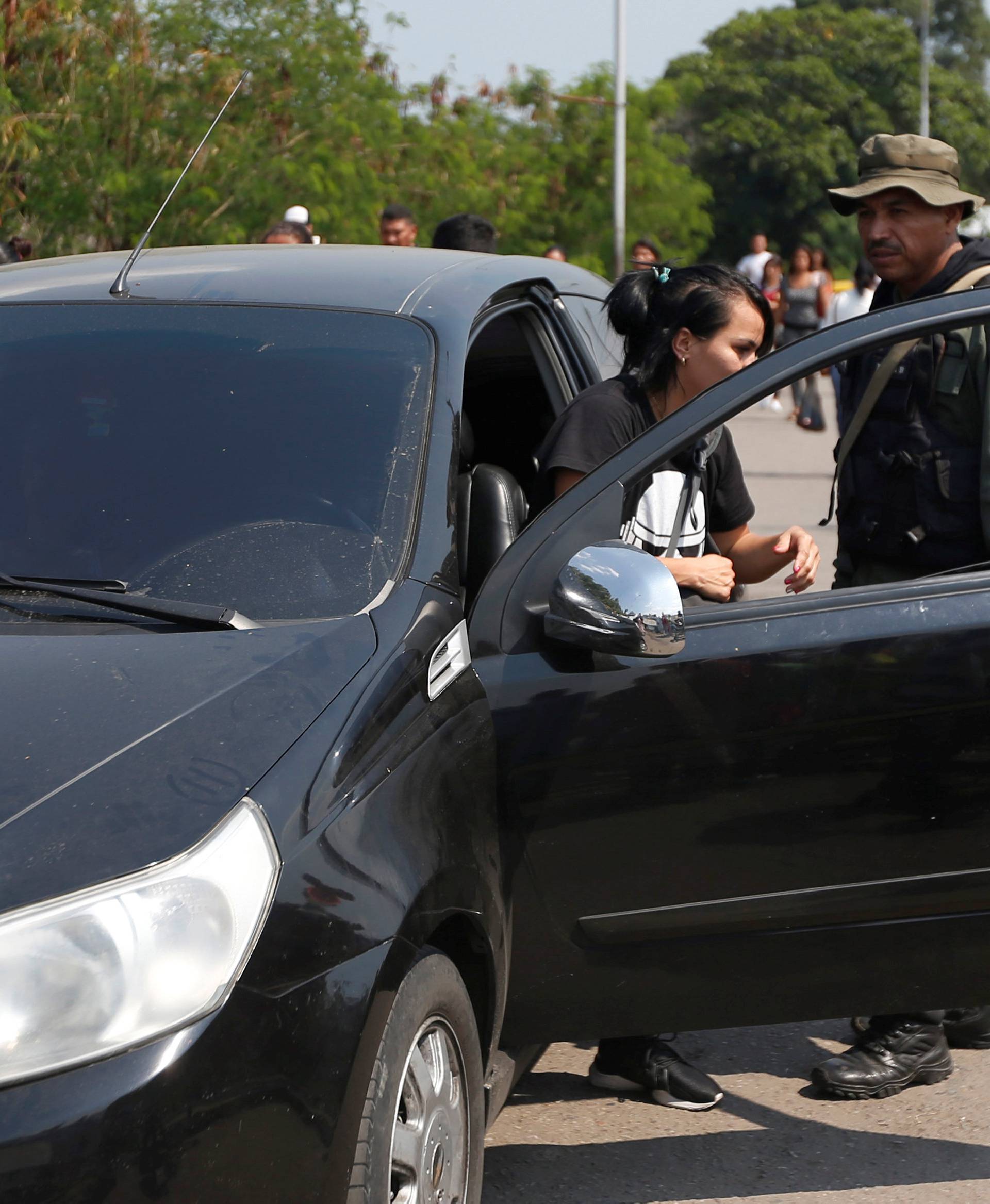 A woman gets out of her car at the request of a Venezuelan guard, on the Francisco de Paula Santander international bridge in Cucuta