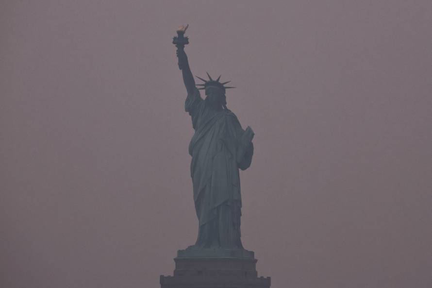The Statue of Liberty is covered by haze and smoke caused by wildfires in Canada, in New York