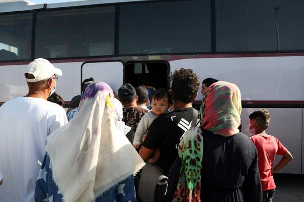 Refugees and migrants from the destroyed Moria camp board a bus to the port, from where they will be transferred to the mainland, on the island of Lesbos
