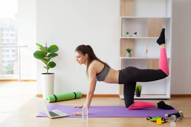 Cheerful active woman doing fitness at fitness studio