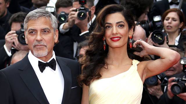 Cast member George Clooney and his wife Amal pose on the red carpet as they arrive for the screening of the film "Money Monster" out of competition during the 69th Cannes Film Festival in Cannes