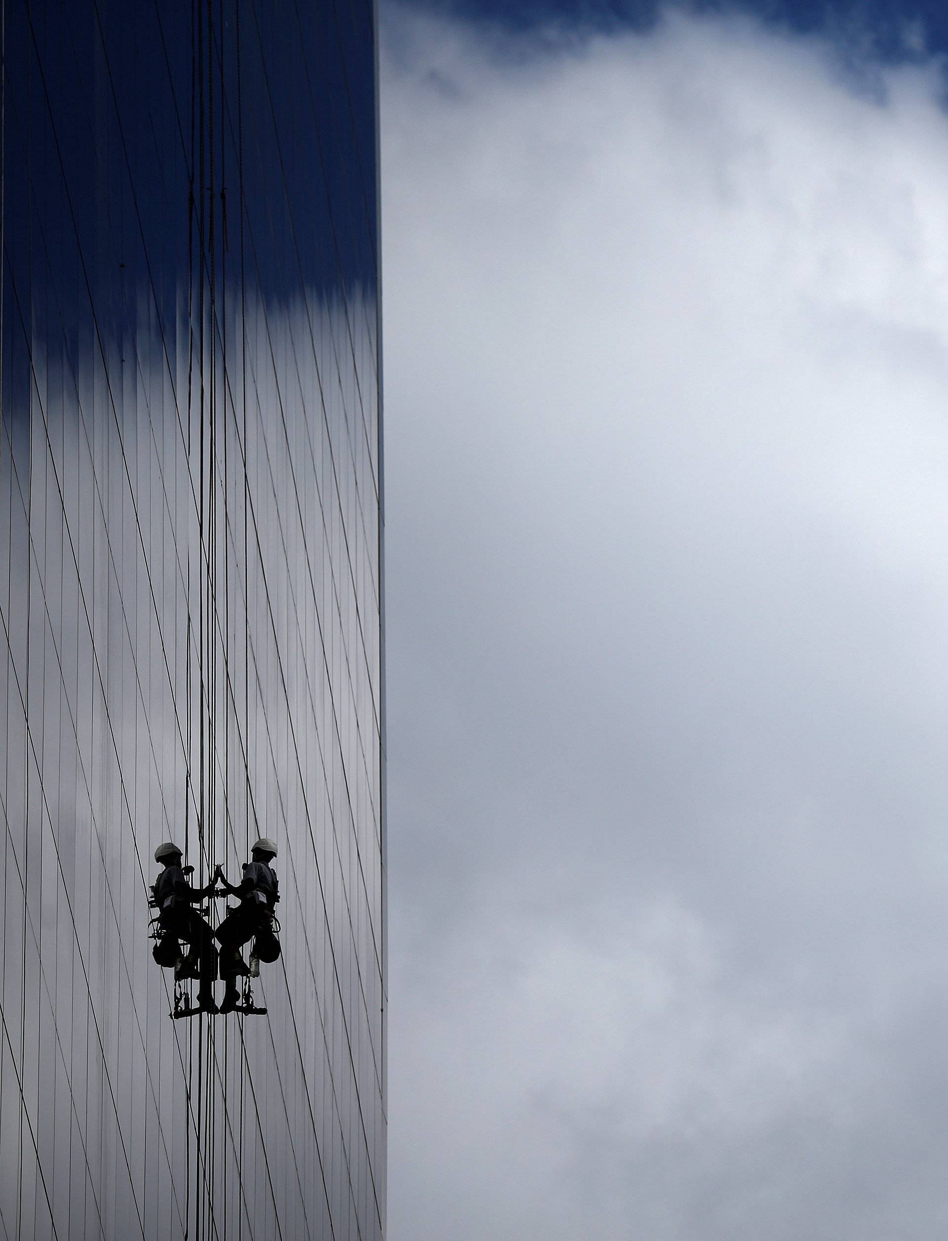 Window cleaner works on the exterior of a hotel outside the 2016 Rio Olympics Park in Rio de Janeiro