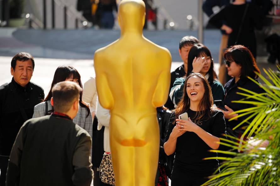 People crowd around an Oscar statue as preparation for the 92nd Academy Awards continues in Los Angeles