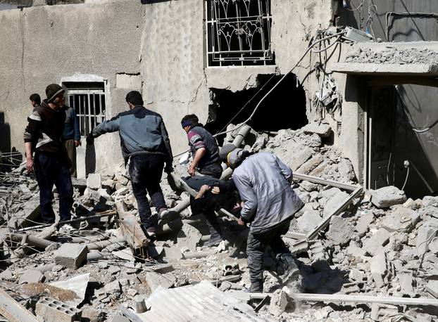 FILE PHOTO: People carry the body of Majid Santiha on a stretcher in the besieged eastern Ghouta town of Hamouriyeh near Damascus