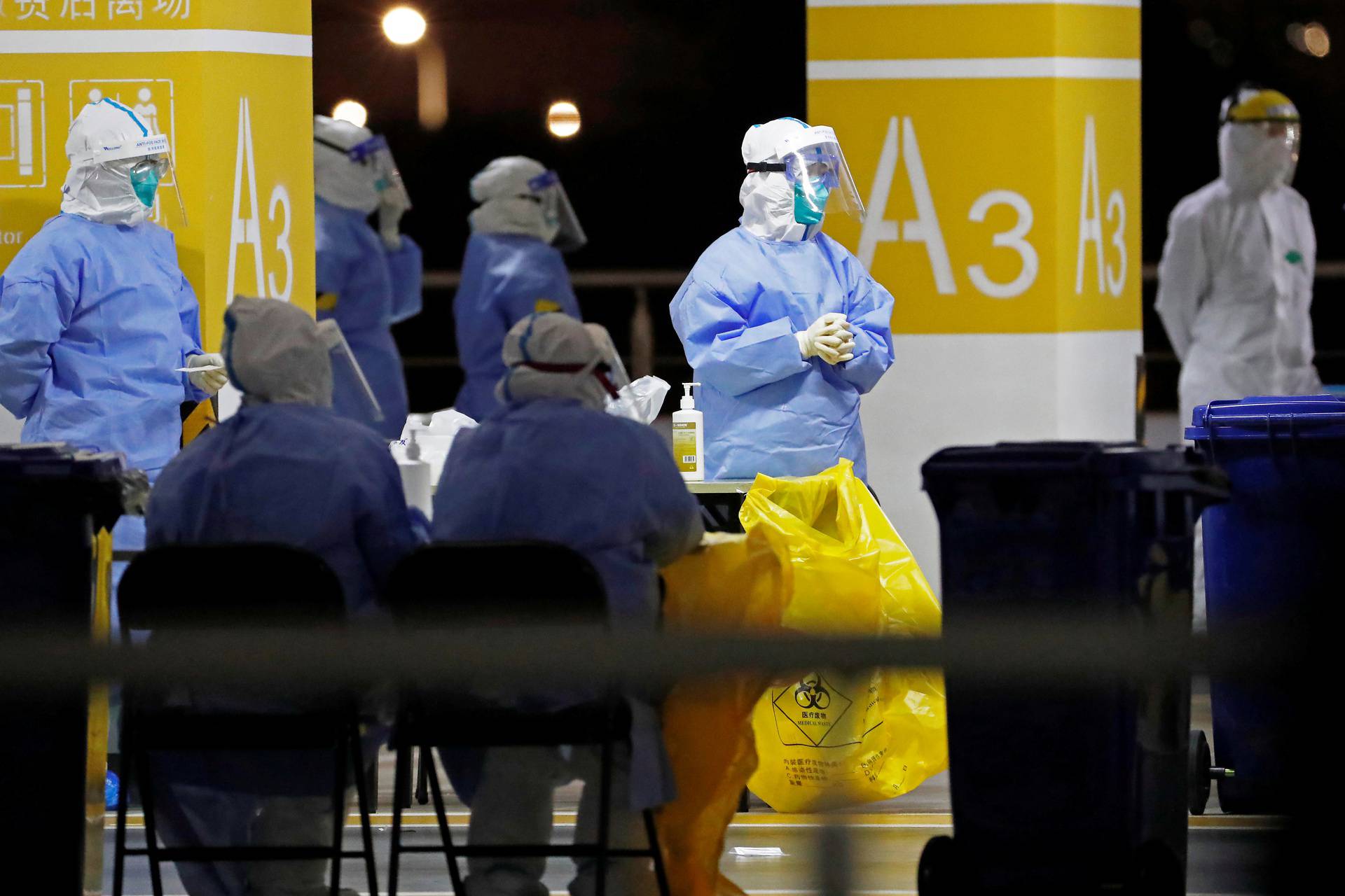 Workers in protective suits are seen at a makeshift nucleic acid testing site at Shanghai Pudong International Airport