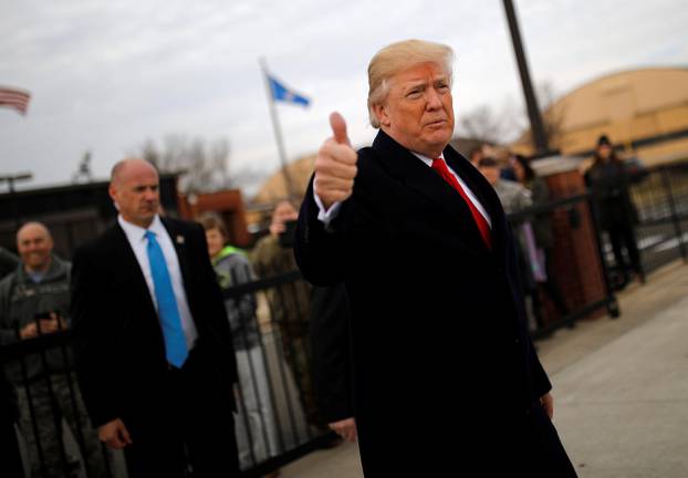 U.S. President Donald Trump gives a thumbs-up to reporters as he boards Air Force One for travel to Palm Beach from Joint Base Andrews