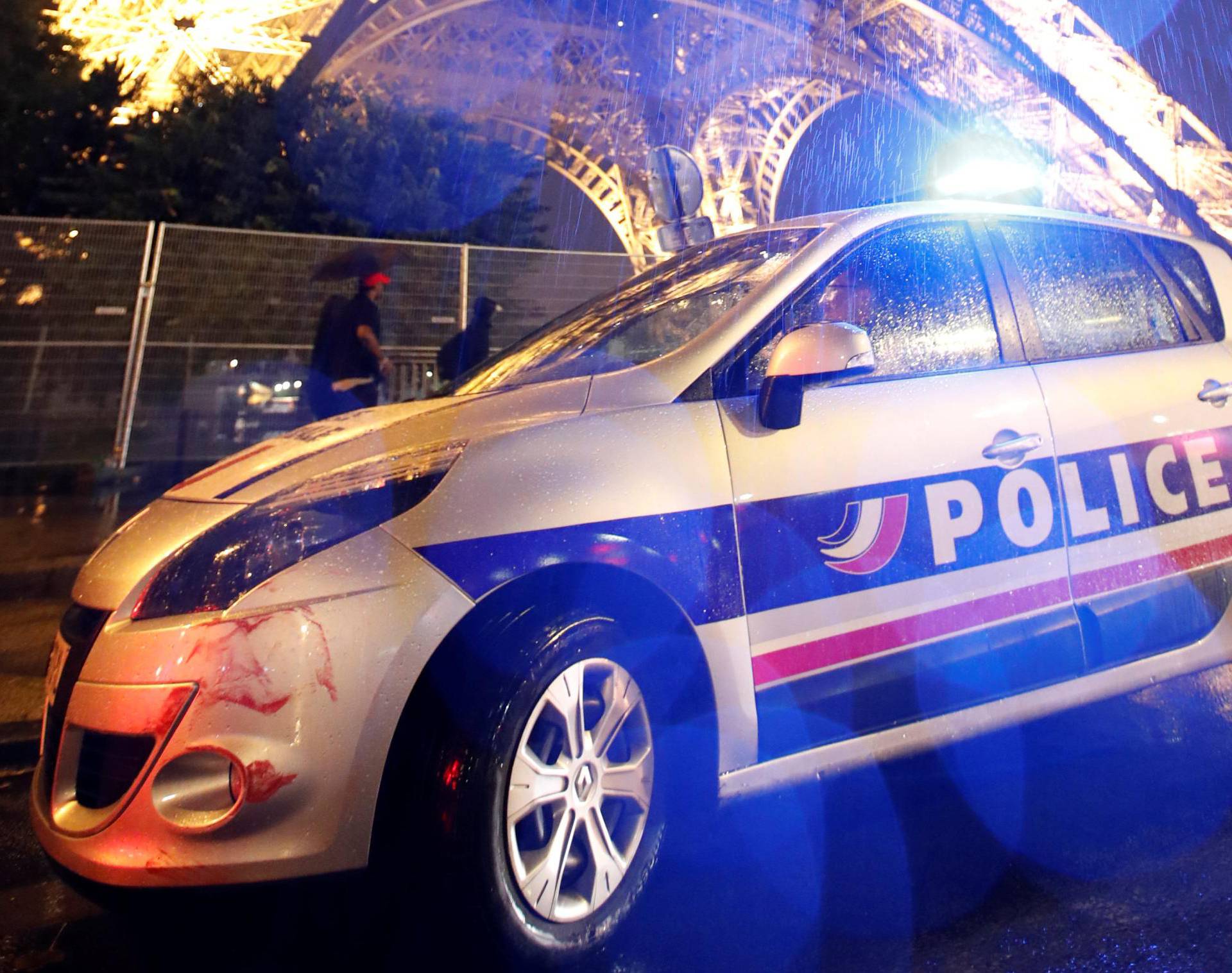 A police car is seen parked in front of the Eiffel Tower in Paris
