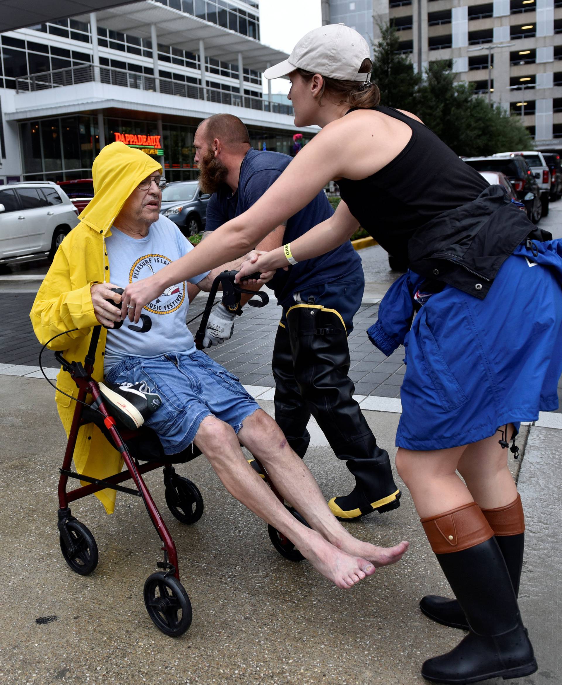 Aid workers push evacuee Frank Andrews into the George R. Brown Convention Center after Hurricane Harvey inundated the Texas Gulf coast with rain causing widespread flooding