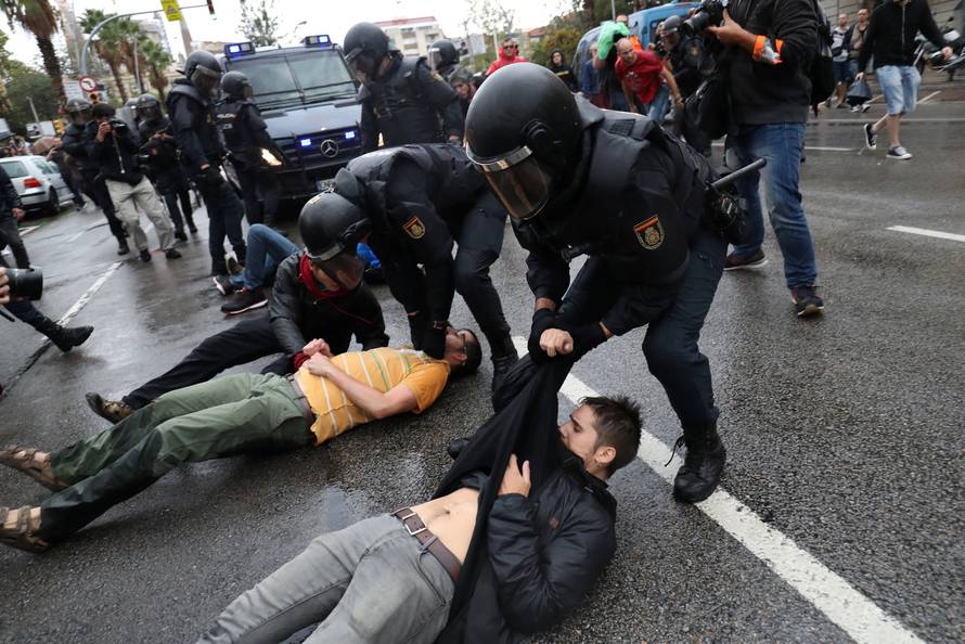 Spanish Civil Guard officers remove demonstrators outside a polling station for the banned independence referendum in Barcelona