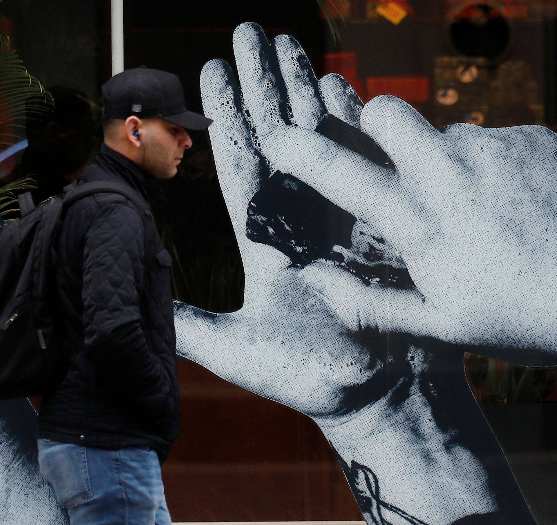 A man walks past a sign in a shop window offering a free hand washing service to customers in Liverpool