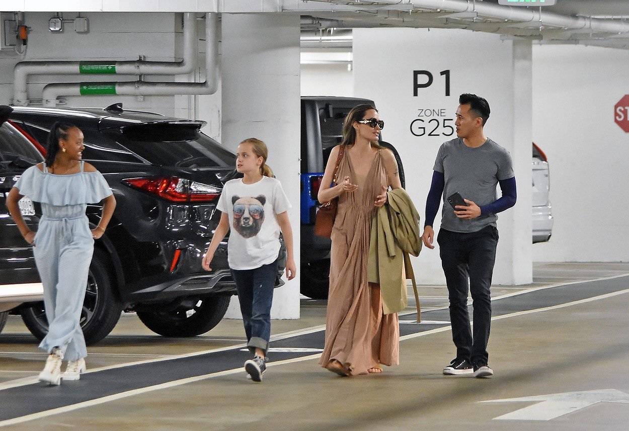 Angelina Jolie wears a plunging v cut beige dress to beat the current heat wave as she is seen shopping in Los Angeles.