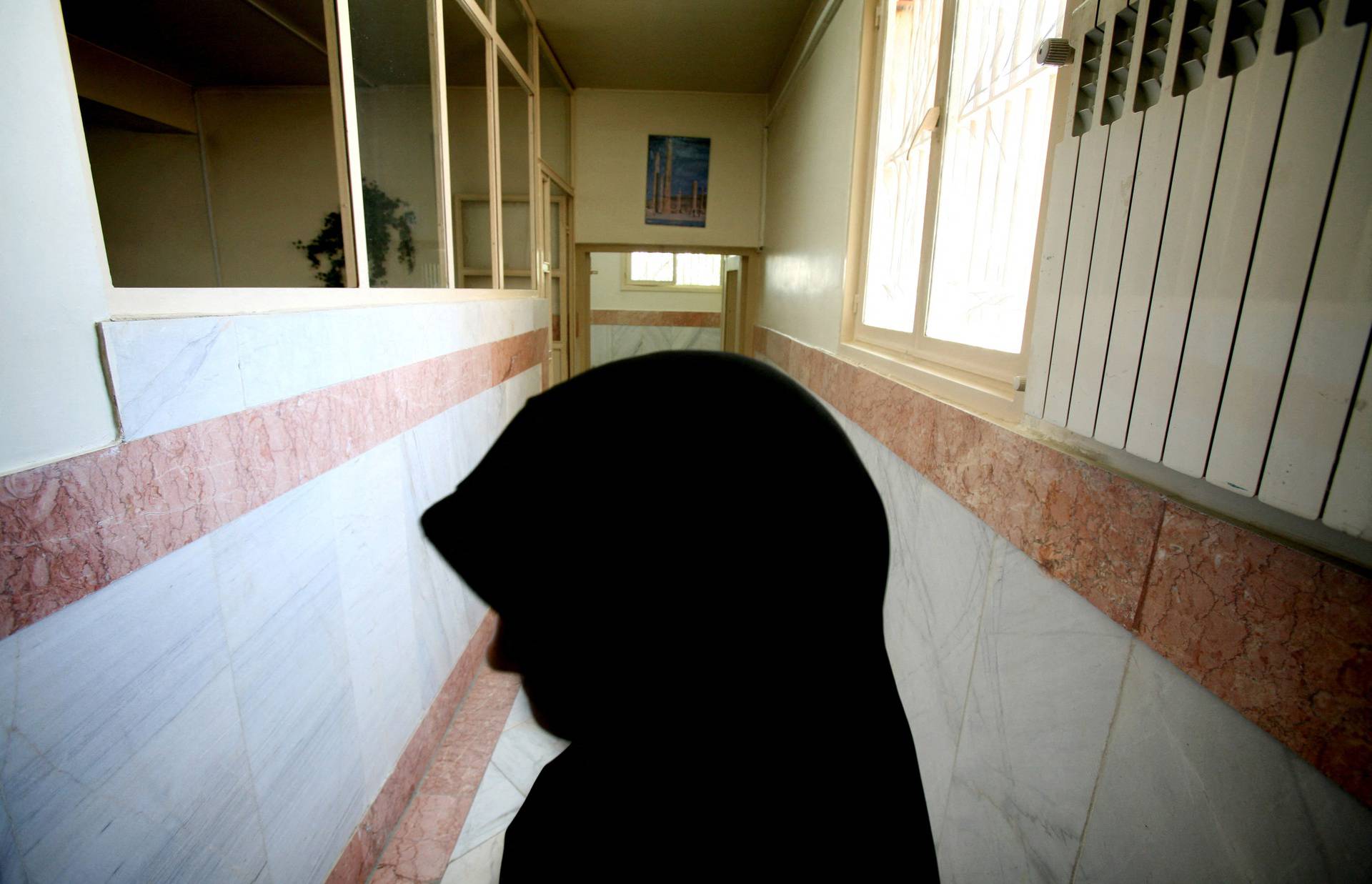 FILE PHOTO: A female prison guard stands along a corridor in Tehran's Evin prison June 13, 2006. Iranian police ..