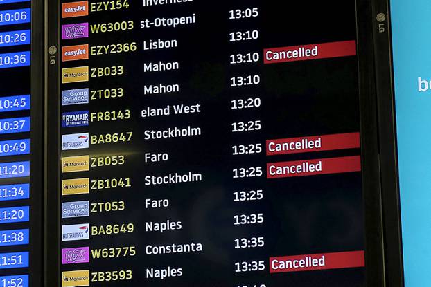 Screens display cancelled Monarch flights after the airline ceased trading, at Luton airport, Britain