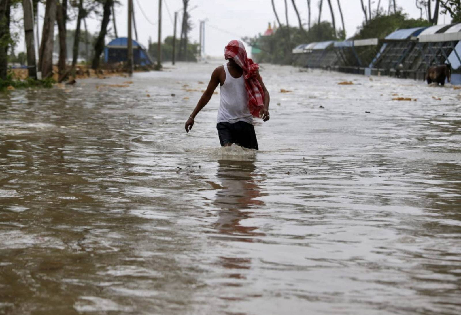 A man wades through a water-logged road after rains ahead of Cyclone Yaas at Digha