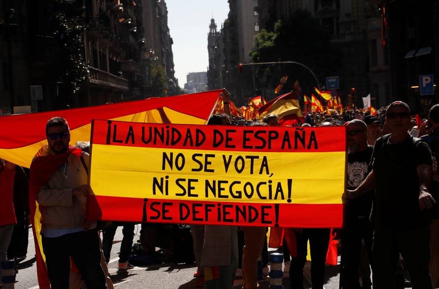 People hold a Spanish flag which reads "The unity of Spain can not be voted on or negotiated, it must be defended" during a pro-union demonstration organised by the Catalan Civil Society organisation in Barcelona