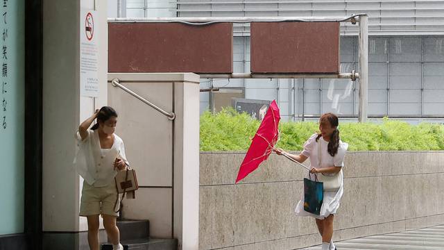 People walk on a street as Typhoon Haikui approaches, in Taipei