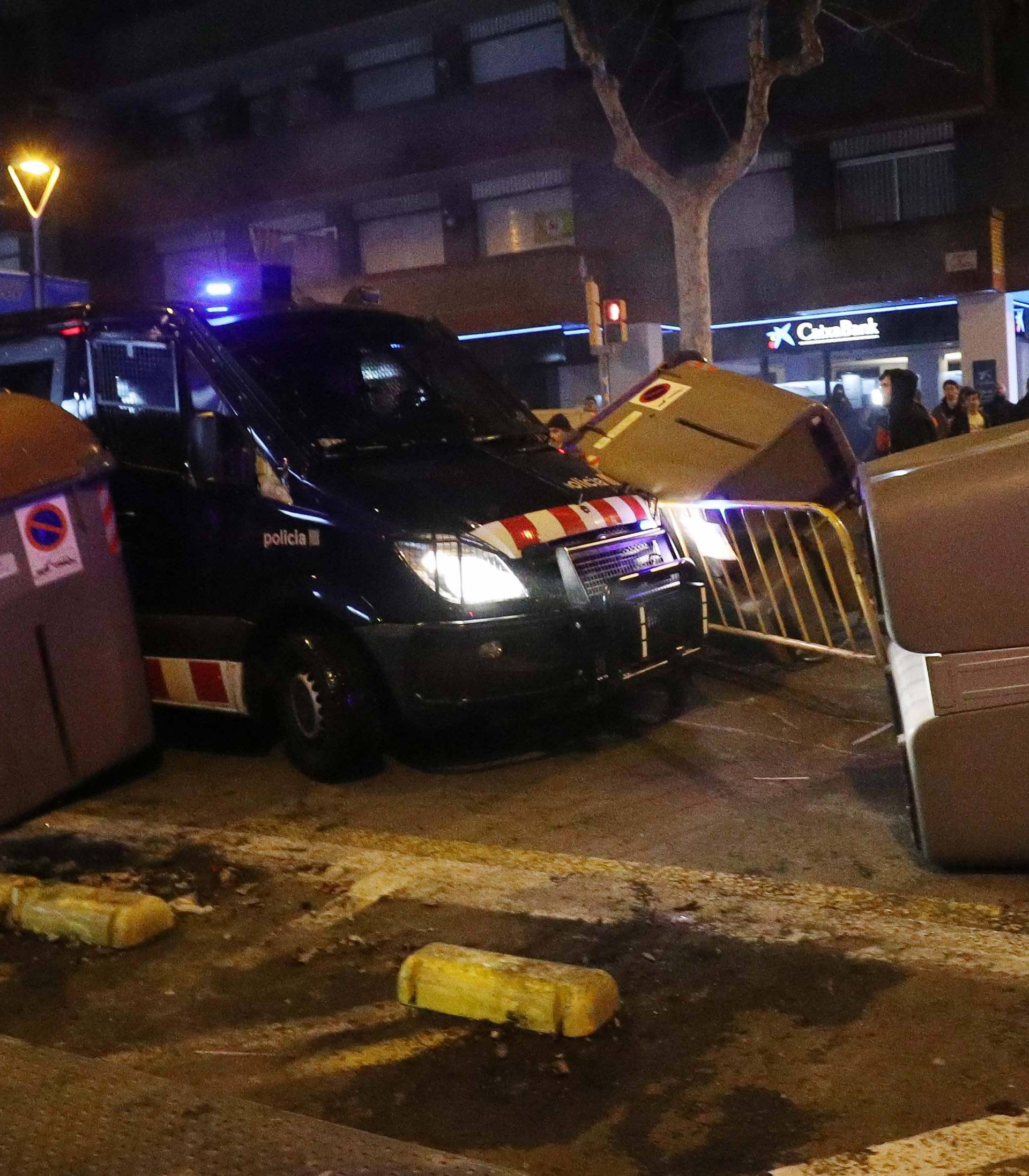 A Catalan police van drives through barricades placed by protestors during skirmishes after former regional president Carles Puigdemont was detained in Germany,  in Barcelona