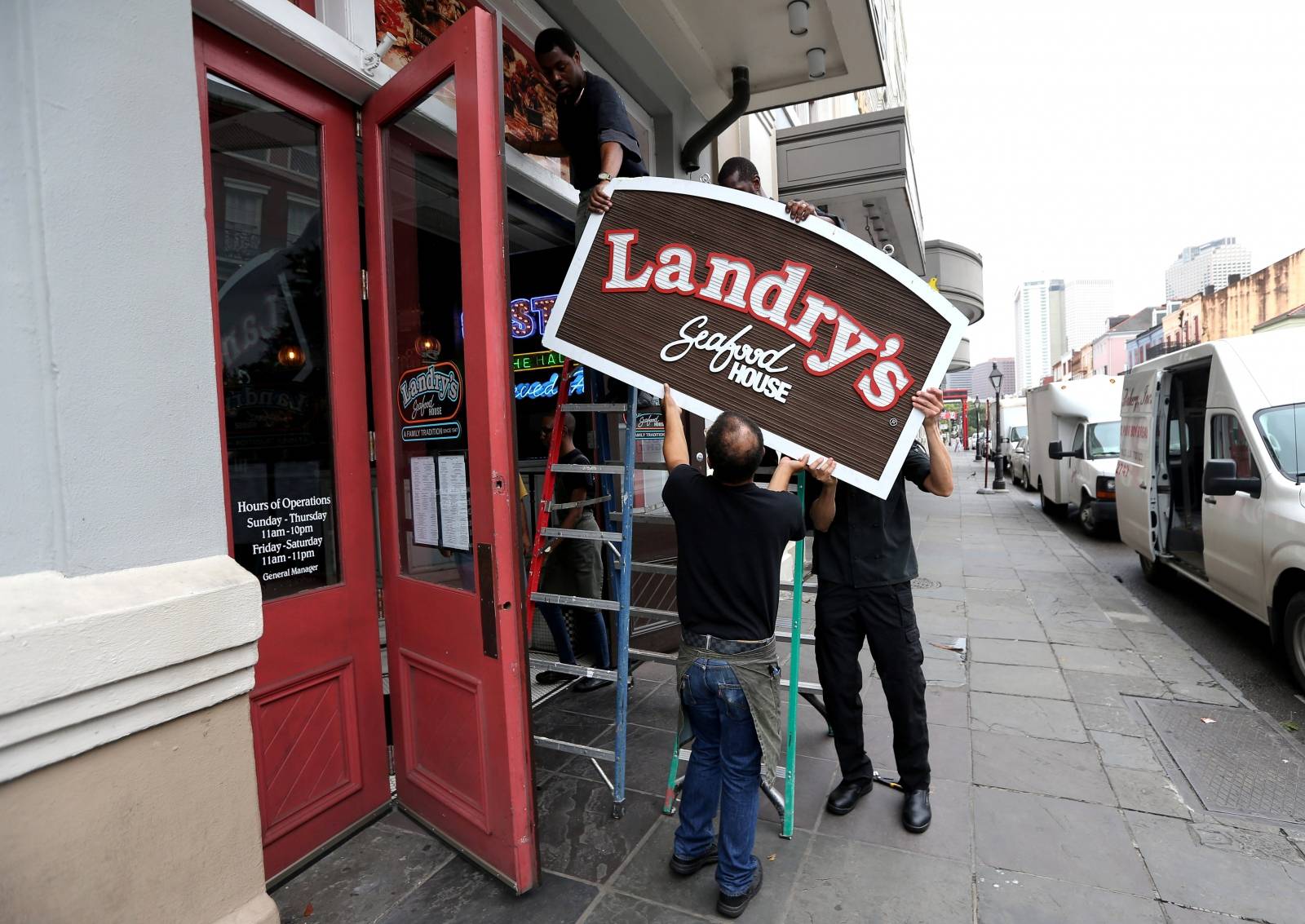 Employees remove a sign in the French Quarter as Tropical Storm Barry approaches land in New Orleans