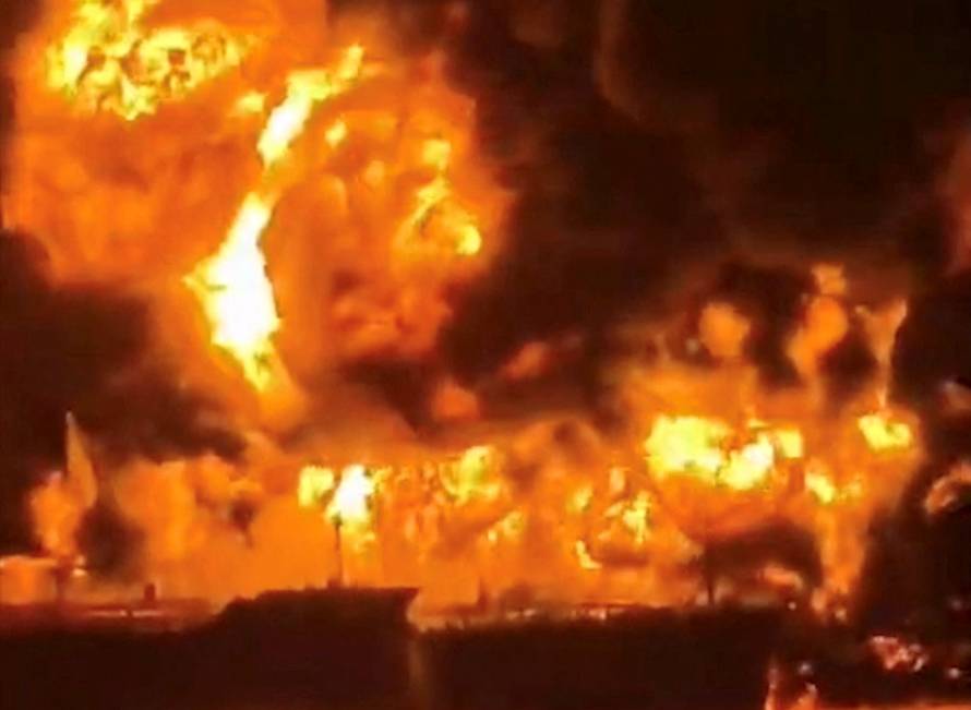 A ship burns, after Iranian explosive-laden boats appear to have attacked two fuel tankers in Iraqi waters setting them ablaze