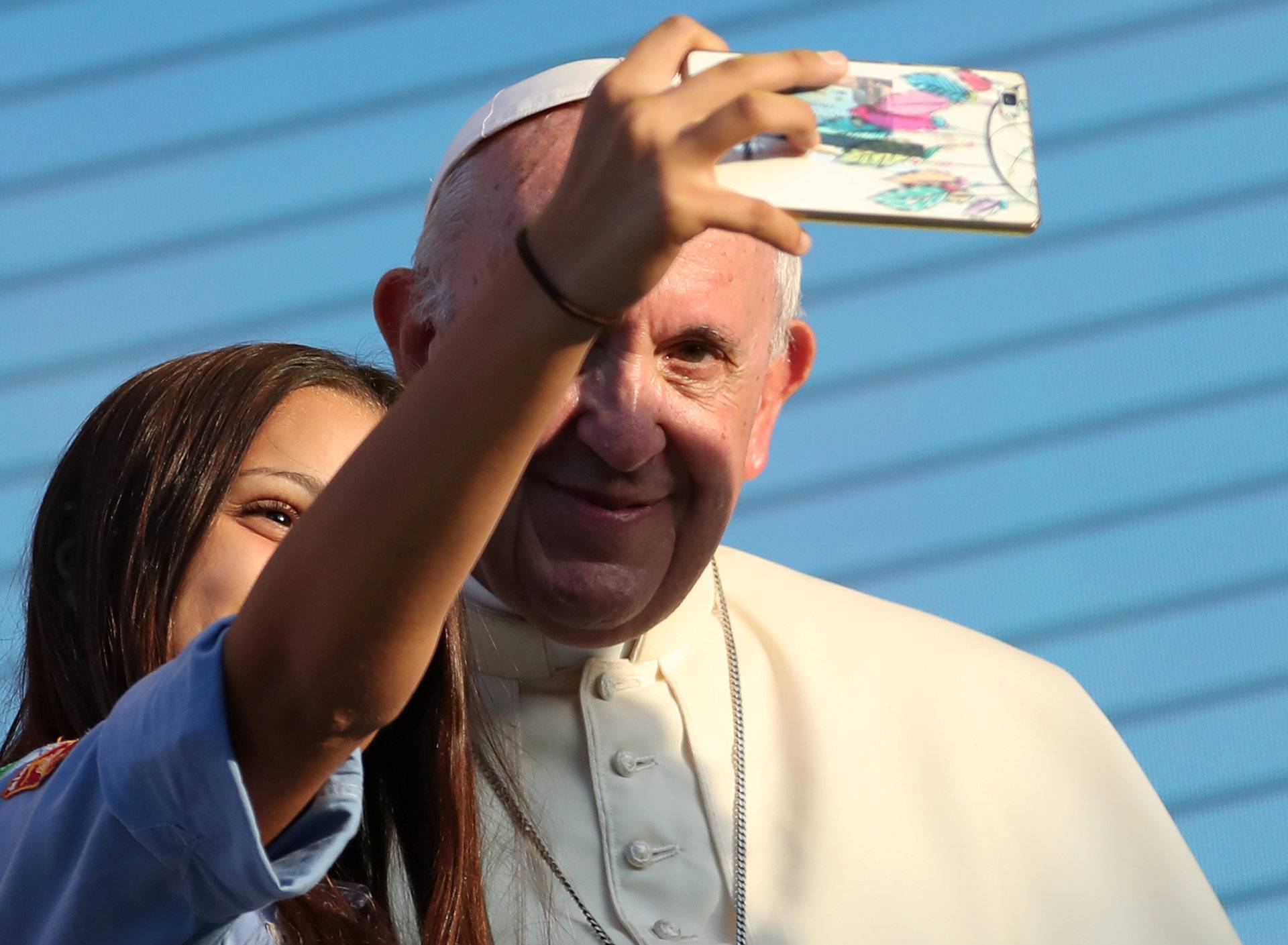 Pope Francis takes a selfie with a faithful as he meets with young people at the Politeama square in Palermo