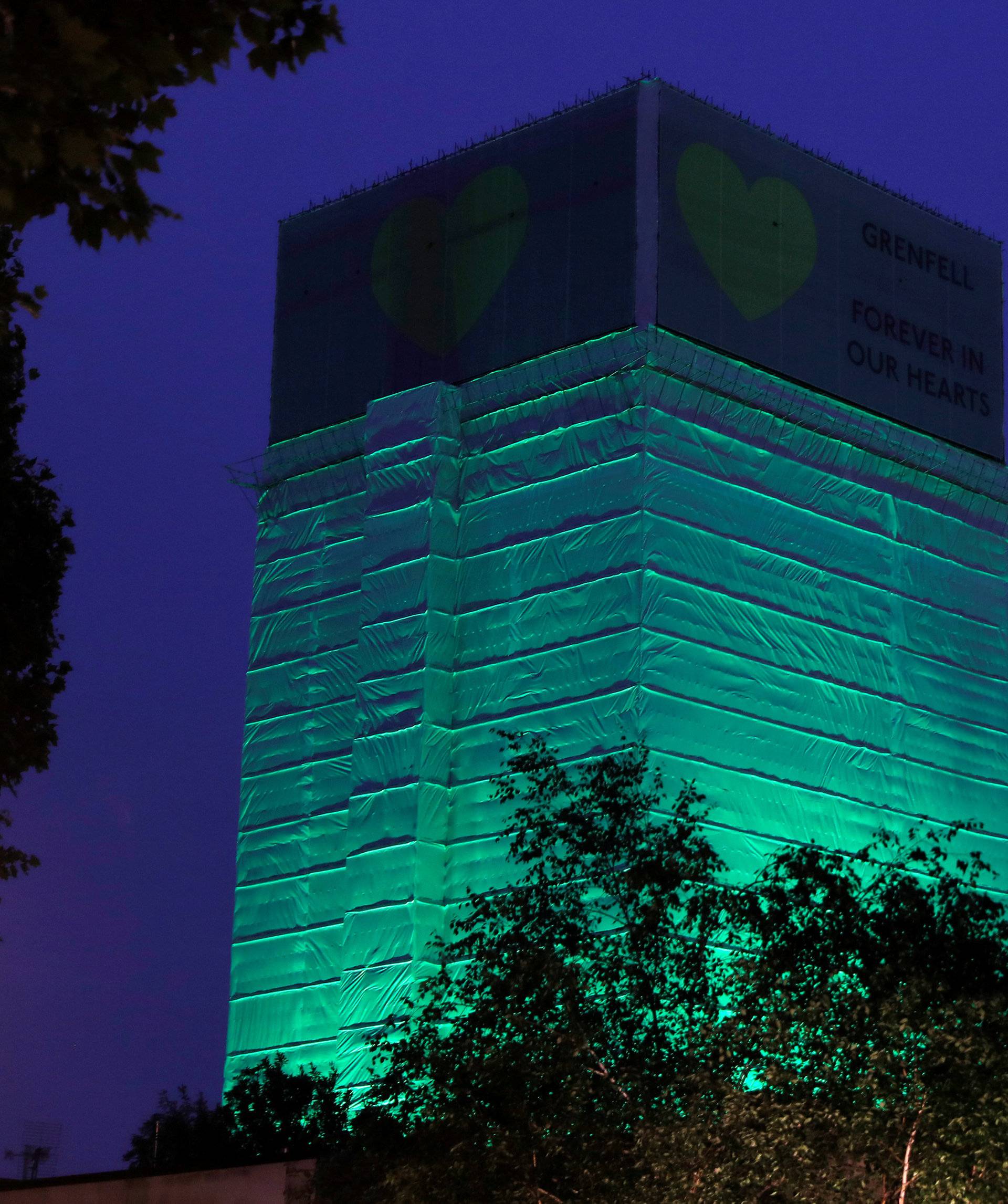 Grenfell Tower is seen covered and illuminated with green light one year after the tower fire in Britain, in London