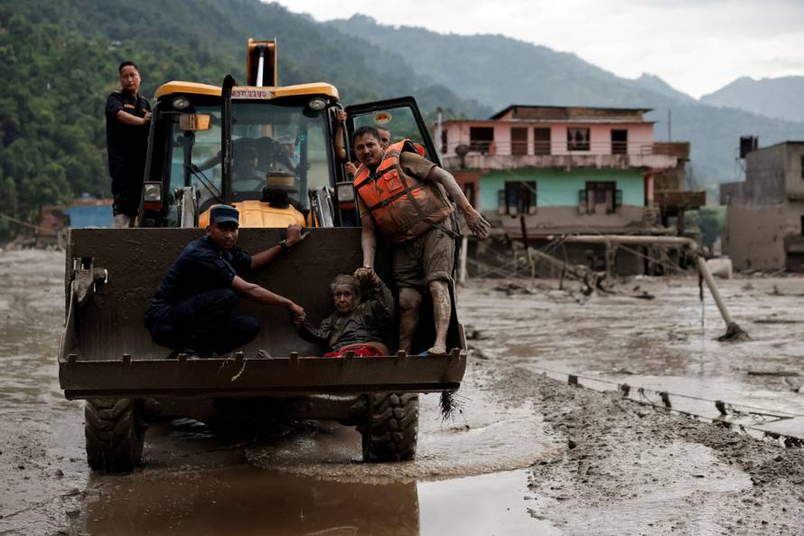 A survivor is transported to a safer place in a JCB following a flash flood at Trishuli, Nepal
