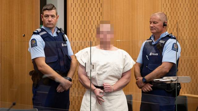Brenton Tarrant, charged for murder, making a sign to the camera during his appearance in the Christchurch District Court