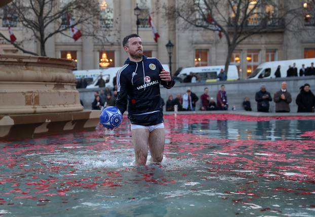 A Scotland fan in the water fountain in Trafalgar Square